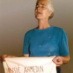 A Bosnian woman holds a cloth embroidered with the name of a loved one who perished in Srebrenica.